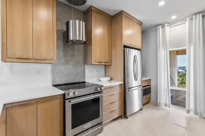 a kitchen with wooden cabinets and stainless steel appliances at High Pointe Resort 414 in Rosemary Beach