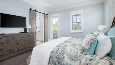 a bedroom with a bed with a flat screen tv at That Summer Feeling in Inlet Beach