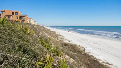 a house on a hill next to a beach at That Summer Feeling in Inlet Beach