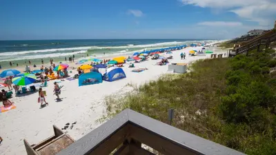 a crowd of people on a beach with umbrellas at That Summer Feeling in Inlet Beach