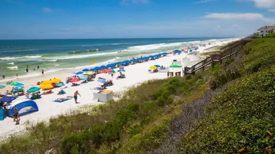 a beach with many people with umbrellas and the ocean at That Summer Feeling in Inlet Beach