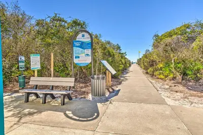a park bench next to a sidewalk with a sign at Half Mi to Inlet Beach Home with Grill and Fire Pit in Inlet Beach