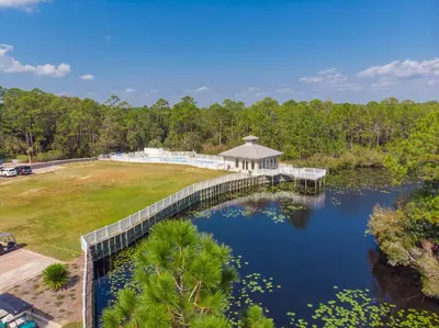 an aerial view of a house with a bridge over a lake at Seagrove Highlands by Panhandle Getaways in Santa Rosa Beach