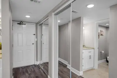 a bathroom with white walls and a glass door at Commodore 801 (3/3) in Panama City Beach