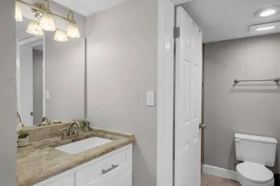 a bathroom with a sink and a toilet and a mirror at Commodore 801 (3/3) in Panama City Beach