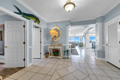 a hallway with blue walls and a room with a table at Hidden Dunes 1501 in Panama City Beach