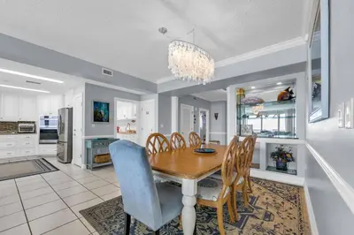 a kitchen and dining room with a wooden table and chairs at Hidden Dunes 1501 in Panama City Beach