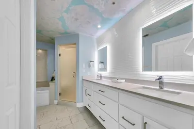 a bathroom with a sink and a mirror and a tub at Hidden Dunes 1501 in Panama City Beach
