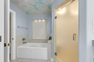 a white bathroom with a tub and a window at Hidden Dunes 1501 in Panama City Beach
