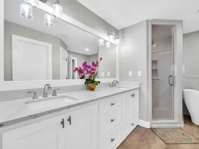 a white bathroom with two sinks and a shower at Hidden Dunes 305 in Panama City Beach
