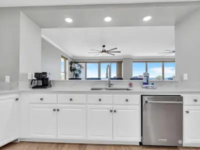 a kitchen with white cabinets and a ceiling fan at Hidden Dunes 305 in Panama City Beach