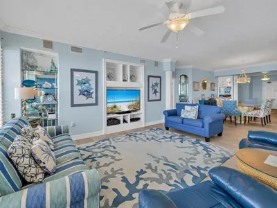 a living room with two blue couches and a table at Hidden Dunes 1704 in Panama City Beach