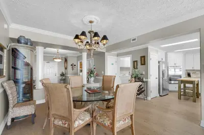 a dining room and kitchen with a table and chairs at Hidden Dunes 1603 in Panama City Beach