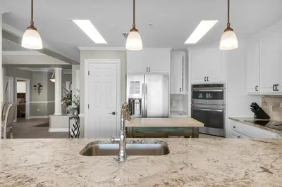 a kitchen with white cabinets and a sink in it at Hidden Dunes 1603 in Panama City Beach