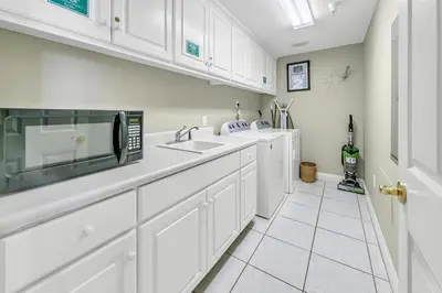 a kitchen with white cabinets and a microwave at Hidden Dunes 1303 in Panama City Beach