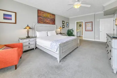 a bedroom with a bed and a orange chair at Hidden Dunes 1303 in Panama City Beach