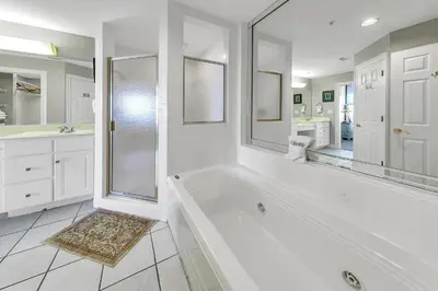 a white bathroom with a tub and a shower at Hidden Dunes 1303 in Panama City Beach