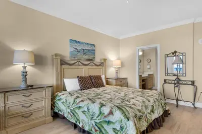 a bedroom with a bed and a dresser and a mirror at Hidden Dunes 1703 in Panama City Beach