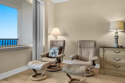two chairs and a table in a room with a window at Hidden Dunes 1703 in Panama City Beach