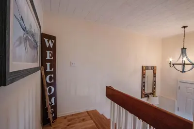 a hallway of a home with a staircase and a chandelier at Sunny Beach by Book That Condo in Panama City Beach