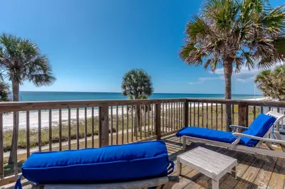 a deck with two blue lounge chairs and a table at Sunny Beach by Book That Condo in Panama City Beach