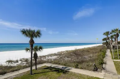 a view of a beach with palm trees and the ocean at Sunny Beach by Book That Condo in Panama City Beach