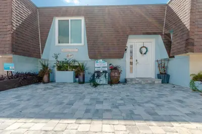 a house with a white door and a sign in front of it at Sunny Beach by Book That Condo in Panama City Beach
