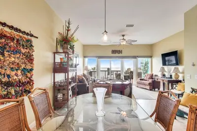 a living room with a glass table and chairs at Seaside Pointe by Book That Condo in Panama City Beach