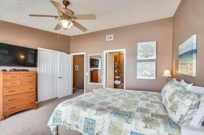 a bedroom with a bed and a ceiling fan at Seaside Pointe by Book That Condo in Panama City Beach