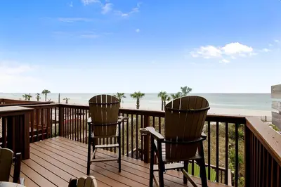 two chairs sitting on a deck overlooking the beach at Seaside Pointe by Book That Condo in Panama City Beach