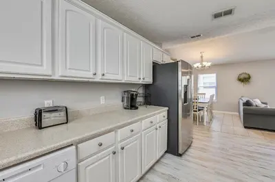 a kitchen with white cabinets and a stainless steel refrigerator at Poolside Cabana by Book That Condo in Panama City Beach