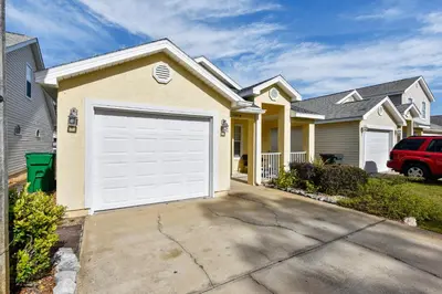 a house with a white garage door in a driveway at Poolside Cabana by Book That Condo in Panama City Beach