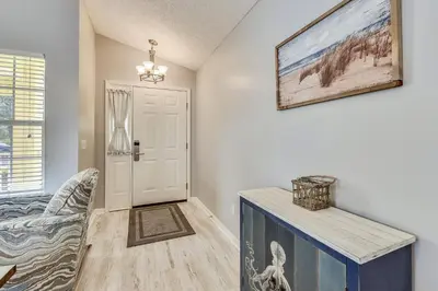 a living room with a table and a door at Poolside Cabana by Book That Condo in Panama City Beach