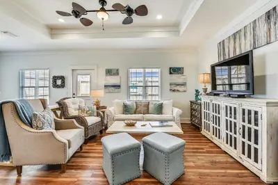 a living room with a couch and a tv at Sandy Feet Retreat by Book That Condo in Panama City Beach
