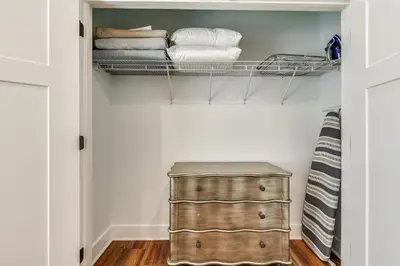 a closet with a wooden chest and towels at Sandy Feet Retreat by Book That Condo in Panama City Beach