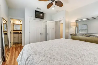 a white bedroom with a bed and a ceiling fan at Sandy Feet Retreat by Book That Condo in Panama City Beach