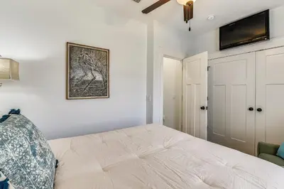 a bedroom with a bed and a tv on the wall at Sandy Feet Retreat by Book That Condo in Panama City Beach