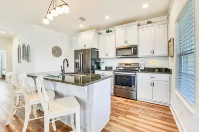 a kitchen with white cabinets and a counter top at Sandy Feet Retreat by Book That Condo in Panama City Beach