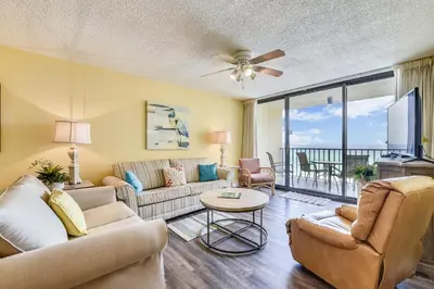 a living room with a couch and a table at Summerhouse 710B by Book That Condo in Panama City Beach