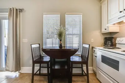 a kitchen with a table and two chairs and a kitchen with windows at C Dreams by Book That Condo in Panama City Beach