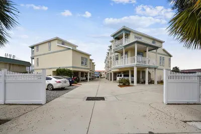 a white fence in front of a house at C Dreams by Book That Condo in Panama City Beach