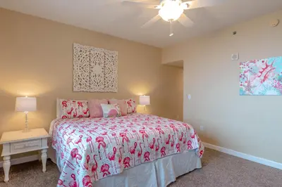 a bedroom with a bed and a ceiling fan at Shores of Panama #612 by Book That Condo in Panama City Beach