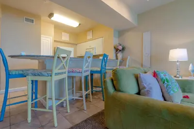 a living room with a couch and a kitchen at Shores of Panama #612 by Book That Condo in Panama City Beach