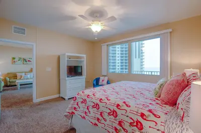 a bedroom with a bed and a tv and a window at Shores of Panama #612 by Book That Condo in Panama City Beach