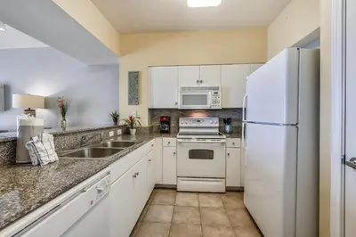 a kitchen with white appliances and a white refrigerator at Shores of Panama #1411 by Book That Condo in Panama City Beach