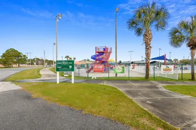 a park with a playground with a sign and palm trees at Shores of Panama #1411 by Book That Condo in Panama City Beach