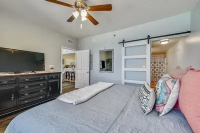 a bedroom with a large bed with a ceiling fan at Shores of Panama #1411 by Book That Condo in Panama City Beach