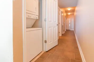 a hallway with a white refrigerator and a tile floor at Shores of Panama #1502 by Book That Condo in Panama City Beach