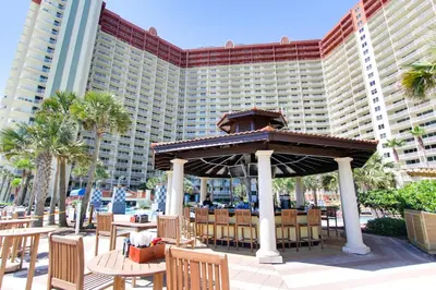 a gazebo with tables and chairs in front of a resort at Shores of Panama #1502 by Book That Condo in Panama City Beach