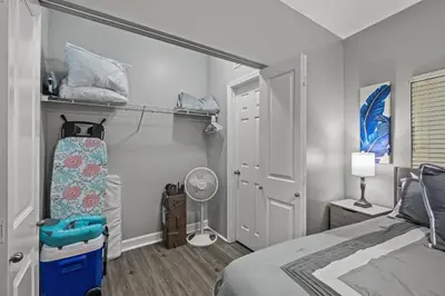 a bedroom with a bed and a room with a fan at Shores of Panama #1502 by Book That Condo in Panama City Beach